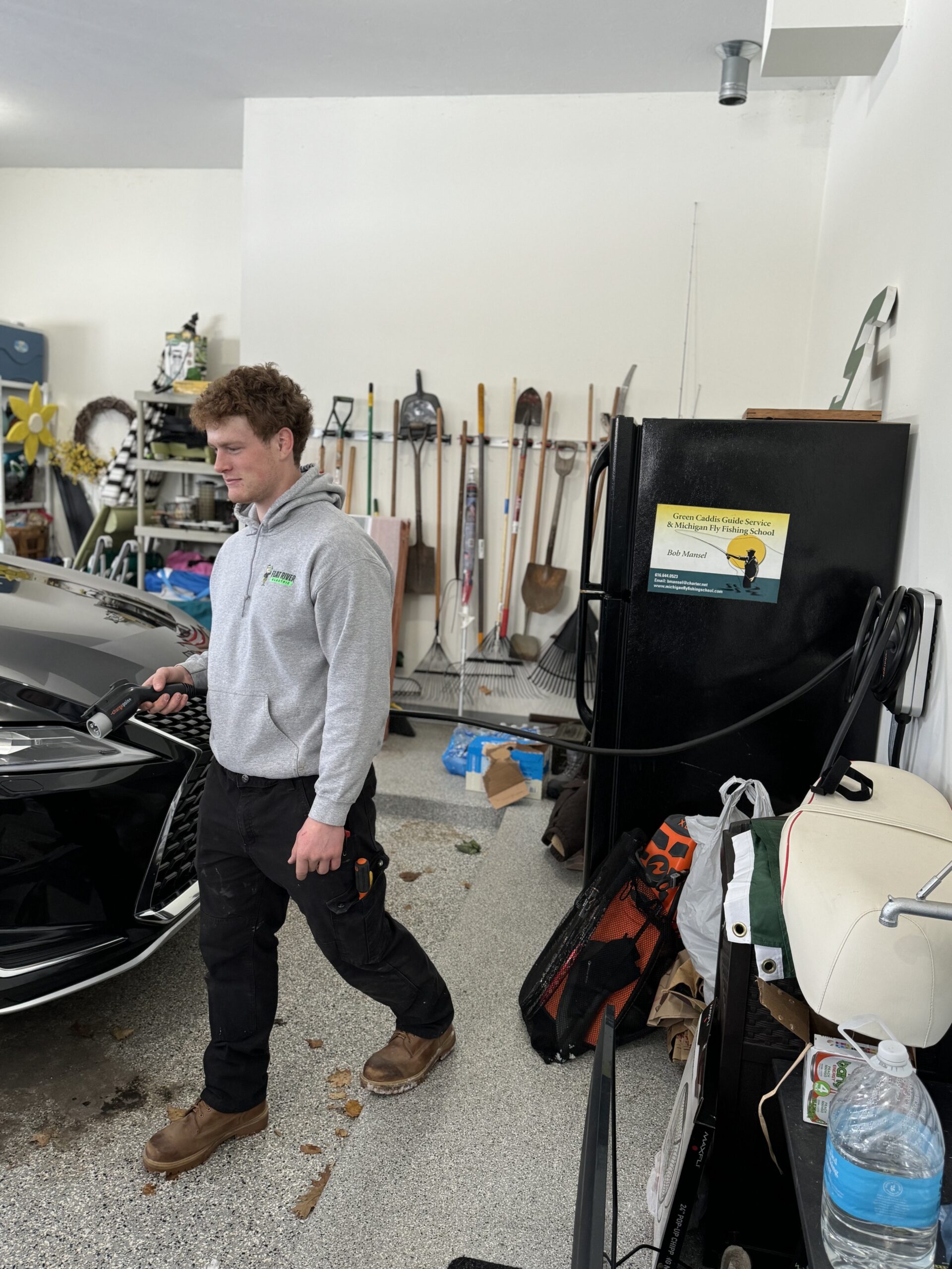 Flat River Electric technician installing a home EV charger in a West Michigan garage.