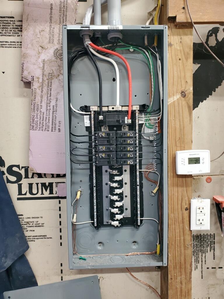 Open residential electrical panel with organized breakers during a service upgrade by Flat River Electric in West Michigan.