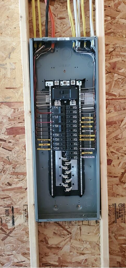 Newly installed residential electrical panel with neatly labeled breakers by Flat River Electric, a licensed West Michigan electrician.