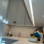 LED under-cabinet lighting in a bright white kitchen