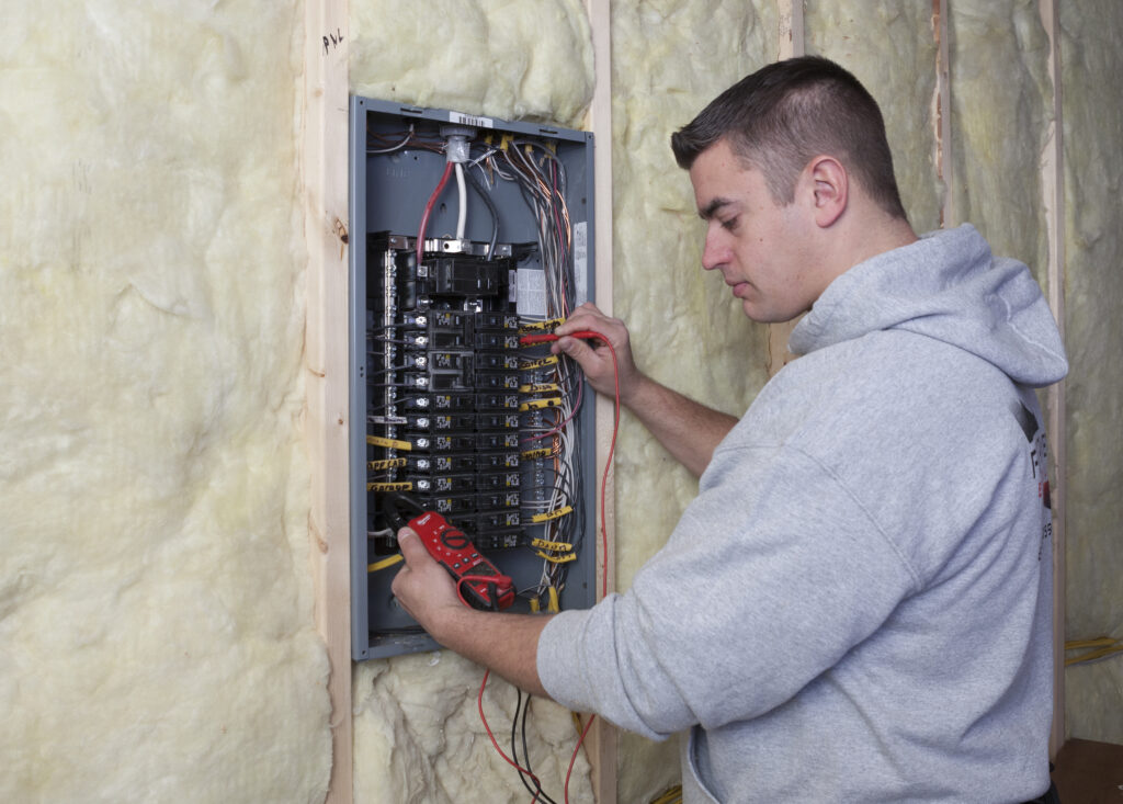 Flat River Electric technician wiring and testing a residential electrical panel during a service upgrade.