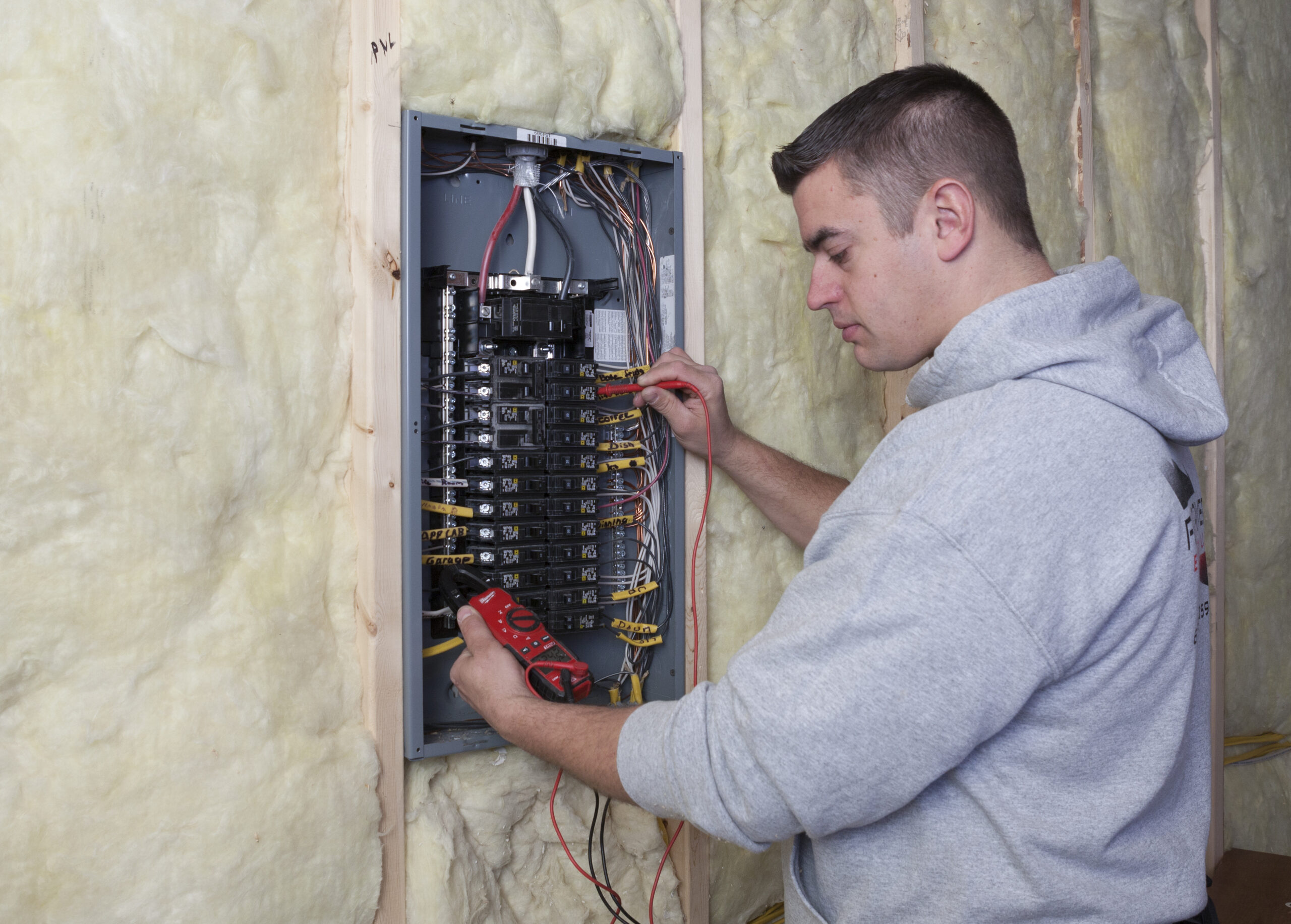 Flat River Electric technician wiring and testing a residential electrical panel during a service upgrade.