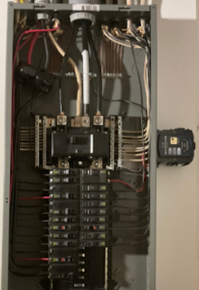 Whole-home surge protector installed alongside a residential electrical panel by Flat River Electric.
