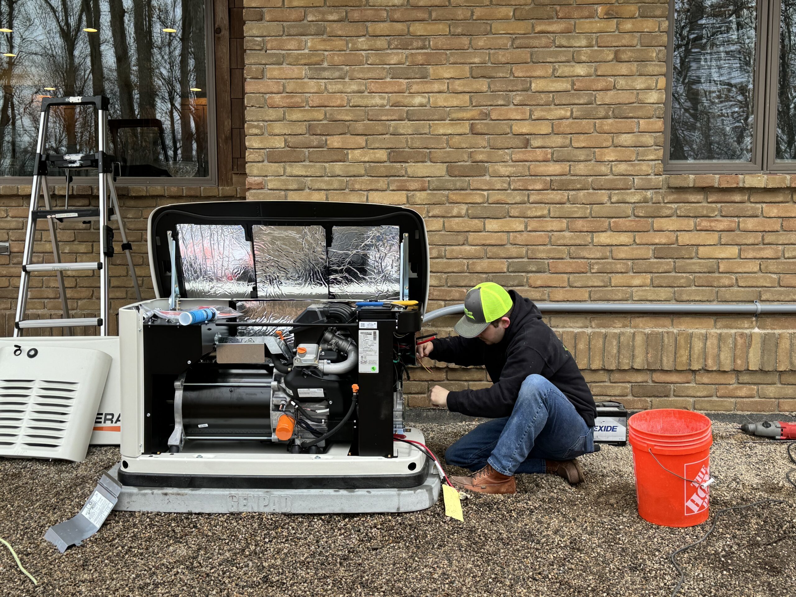Flat River Electric technicians installing a whole-home standby generator at an Ada, MI home