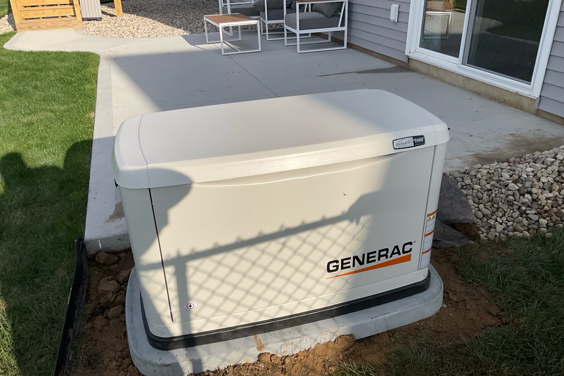 Generac home standby generator installed next to a back patio in West Michigan
